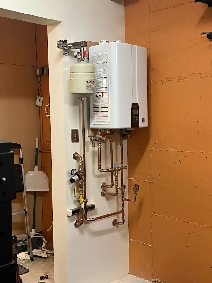 Plumbing technician inspecting water heater connections in Pine Level